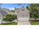Rear exterior of a two-story house featuring an attached garage, siding, and fenced yard at 124 Kingsport Rd, Holly Springs, NC 27540