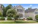 Attractive two-story home showcasing gray siding, black shutters, a charming porch, and blossoming trees at 124 Kingsport Rd, Holly Springs, NC 27540