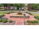 Charming fountain area with brick pavers, manicured bushes, and park benches in a well maintained community at 124 Kingsport Rd, Holly Springs, NC 27540