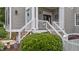Inviting front porch featuring a colorful blue door, wooden stairs, and an inviting welcome decor at 124 Kingsport Rd, Holly Springs, NC 27540