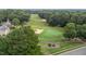 Scenic view of a lush golf course with sand traps and fairways surrounded by mature trees, beside a quiet street at 124 Kingsport Rd, Holly Springs, NC 27540