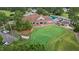 Aerial view of golf course and clubhouse offering outdoor dining, a putting green and golf cart parking at 124 Kingsport Rd, Holly Springs, NC 27540