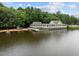 Wide view of the lakefront with a quaint boathouse featuring a dock, swim area and covered porch for relaxing lake activities at 124 Kingsport Rd, Holly Springs, NC 27540