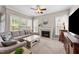 Comfortable living room with fireplace, large windows, and plush gray sofa at 124 Kingsport Rd, Holly Springs, NC 27540