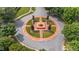 Aerial view of a beautifully landscaped roundabout with a fountain and manicured greenery in the community at 124 Kingsport Rd, Holly Springs, NC 27540
