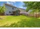 Lush backyard featuring a screened porch, green lawn, and mature trees, perfect for outdoor enjoyment at 128 Palmdale Ct, Holly Springs, NC 27540