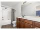 Bright bathroom featuring wood-look flooring, shower-tub combo, and dark wood cabinets at 128 Palmdale Ct, Holly Springs, NC 27540