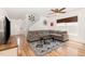 Spacious living room with hardwood floors, a large gray sofa, and a ceiling fan at 128 Palmdale Ct, Holly Springs, NC 27540