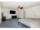 Spacious bedroom with a ceiling fan, TV, and view into another room at 128 Palmdale Ct, Holly Springs, NC 27540