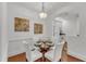 Cozy dining area with a modern chandelier, round glass table, and views of the kitchen and hallway at 1310 Durlain Dv # 103, Raleigh, NC 27614