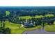 Aerial view of golf course, clubhouse, pond, and surrounding neighborhood with lush greenery at 150 Saint Mellion St, Raleigh, NC 27603