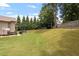 Large backyard with a basketball hoop, a seating area, and lush green grass at 150 Saint Mellion St, Raleigh, NC 27603