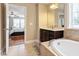 Bright bathroom shows a soaking tub, a sink, and a view to the main bedroom at 150 Saint Mellion St, Raleigh, NC 27603