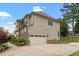 A charming home exterior boasts a two-car garage, stone accents, tidy landscaping, and a paved driveway on a sunny day at 150 Saint Mellion St, Raleigh, NC 27603