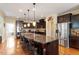 Modern kitchen featuring dark wood cabinets, stainless steel appliances, and a large island with bar seating at 150 Saint Mellion St, Raleigh, NC 27603
