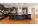 Well-equipped kitchen with a large island, dark cabinetry, stainless steel appliances, and hardwood floors at 150 Saint Mellion St, Raleigh, NC 27603