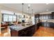 Modern kitchen with stainless appliances, dark cabinets and granite countertops opens to the cozy Gathering room at 150 Saint Mellion St, Raleigh, NC 27603