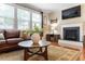 Cozy living room with a leather sofa, a fireplace, and a large window that provides ample natural light at 150 Saint Mellion St, Raleigh, NC 27603