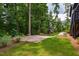 Serene backyard with patio, lush greenery, and playset, offers an ideal outdoor retreat for relaxation and play at 153 W Beech Slope Ct, Chapel Hill, NC 27517