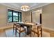 Dining area features a modern chandelier, large windows, and backyard views at 153 W Beech Slope Ct, Chapel Hill, NC 27517