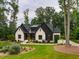 A modern farmhouse-style house with a white brick exterior, black accents, and a well-maintained lawn at 153 W Beech Slope Ct, Chapel Hill, NC 27517