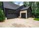 The property features a three-car garage with black doors and brick accents, providing ample parking and storage at 153 W Beech Slope Ct, Chapel Hill, NC 27517