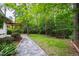 Lush backyard with a stone pathway leading to a charming swing and ample greenery at 1606 Sycamore St, Durham, NC 27707