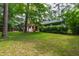 Expansive backyard view, featuring lush greenery, a pergola, and mature trees creating a private oasis at 1606 Sycamore St, Durham, NC 27707