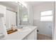 Bright bathroom featuring a white sink, tiled walls, and a large mirror above the vanity at 1606 Sycamore St, Durham, NC 27707