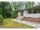 Charming single-story home with white brick, green trim, and a well-manicured front yard landscape at 1606 Sycamore St, Durham, NC 27707