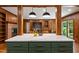 Open-concept kitchen featuring a marble island, wood-paneled walls, and modern pendant lighting at 1606 Sycamore St, Durham, NC 27707