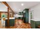 Modern kitchen with herringbone floors, dark green cabinets, and stainless steel appliances at 1606 Sycamore St, Durham, NC 27707
