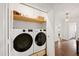 Laundry closet with a modern washer and dryer set, complemented by wooden shelving at 1606 Sycamore St, Durham, NC 27707