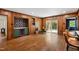 Open living room with wood paneled walls, herringbone floors, bar area, and patio access at 1606 Sycamore St, Durham, NC 27707