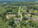 Aerial view of a house with a pool located in a quiet neighborhood surrounded by lush trees at 171 St. Jiles Dr, Clayton, NC 27520