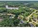 An aerial view reveals a house in a quiet neighborhood with a pool near a lake surrounded by mature trees at 171 St. Jiles Dr, Clayton, NC 27520