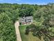 Overhead view of a house surrounded by lush greenery, featuring a long driveway and beautifully maintained grounds at 171 St. Jiles Dr, Clayton, NC 27520