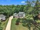 Stunning aerial view of a home nestled among lush trees with a long driveway and manicured lawn at 171 St. Jiles Dr, Clayton, NC 27520