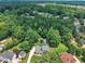 An aerial view shows a home with a pool surrounded by lush trees in a beautiful neighborhood at 171 St. Jiles Dr, Clayton, NC 27520