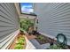 Landscaped back porch featuring brick pavers, flowering plants and comfortable seating at 171 St. Jiles Dr, Clayton, NC 27520