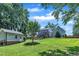 Sprawling backyard with well-maintained lawn, mature trees, pool with lounge furniture, and a charming shed at 171 St. Jiles Dr, Clayton, NC 27520