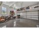 A large garage with a clean epoxy floor, organized shelving, and ample space for vehicles and storage at 171 St. Jiles Dr, Clayton, NC 27520