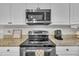 Modern kitchen appliances include a stainless steel microwave, oven and cooktop with granite countertops at 171 St. Jiles Dr, Clayton, NC 27520