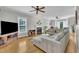 Spacious living room with fireplace, hardwood floors, ceiling fan, and a large sectional couch at 171 St. Jiles Dr, Clayton, NC 27520