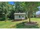 Charming backyard shed with brick foundation, painted siding, and ample natural light surrounded by a green yard at 171 St. Jiles Dr, Clayton, NC 27520