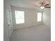This bright bedroom features neutral carpeting, two windows, and a ceiling fan with a light at 1848 Glenn St, Burlington, NC 27217