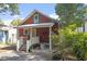 Lovely backyard has a red house, a covered porch, and garden areas at 1916 Hart St, Durham, NC 27703