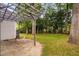 A backyard with a stone patio and pergola offers a serene outdoor living space surrounded by lush greenery and mature trees at 202 Stoneleigh Dr, Cary, NC 27511
