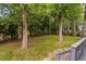 Lush backyard featuring mature trees, a well-maintained lawn, and a black metal fence at 202 Stoneleigh Dr, Cary, NC 27511