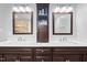 A bathroom with double sinks, white quartz countertops, dark wood cabinets, mirrors and decorative sconce lighting at 202 Stoneleigh Dr, Cary, NC 27511